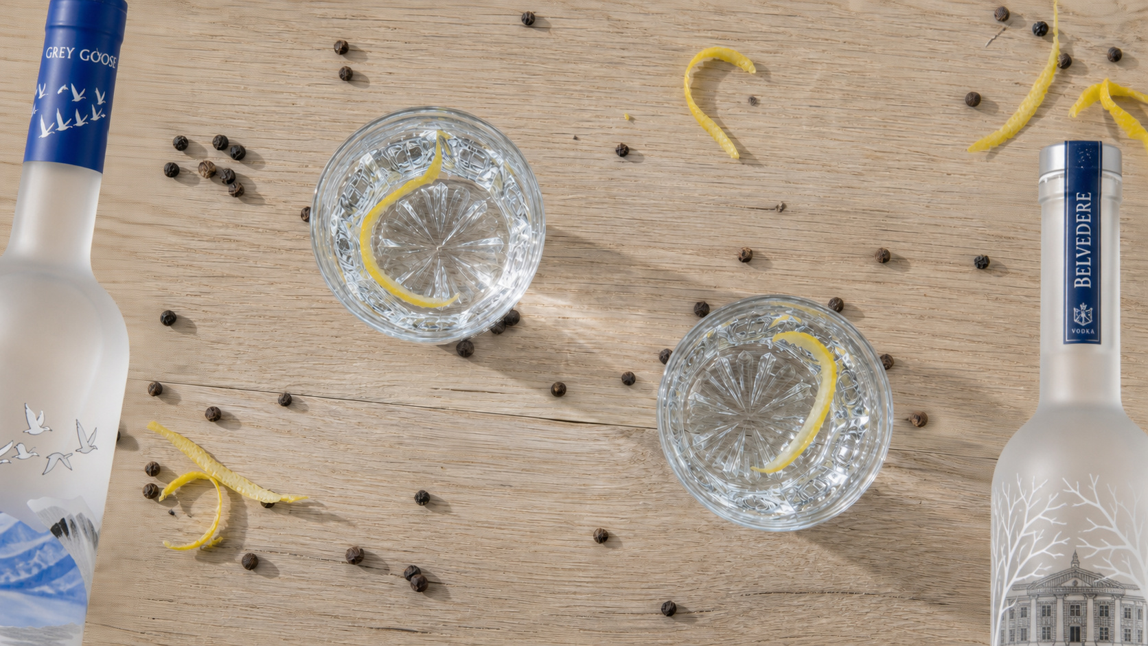 Zwei Nosing-Gläser mit Wodka von oben, dahinter Grey Goose und Belvedere Flaschen angedeutet