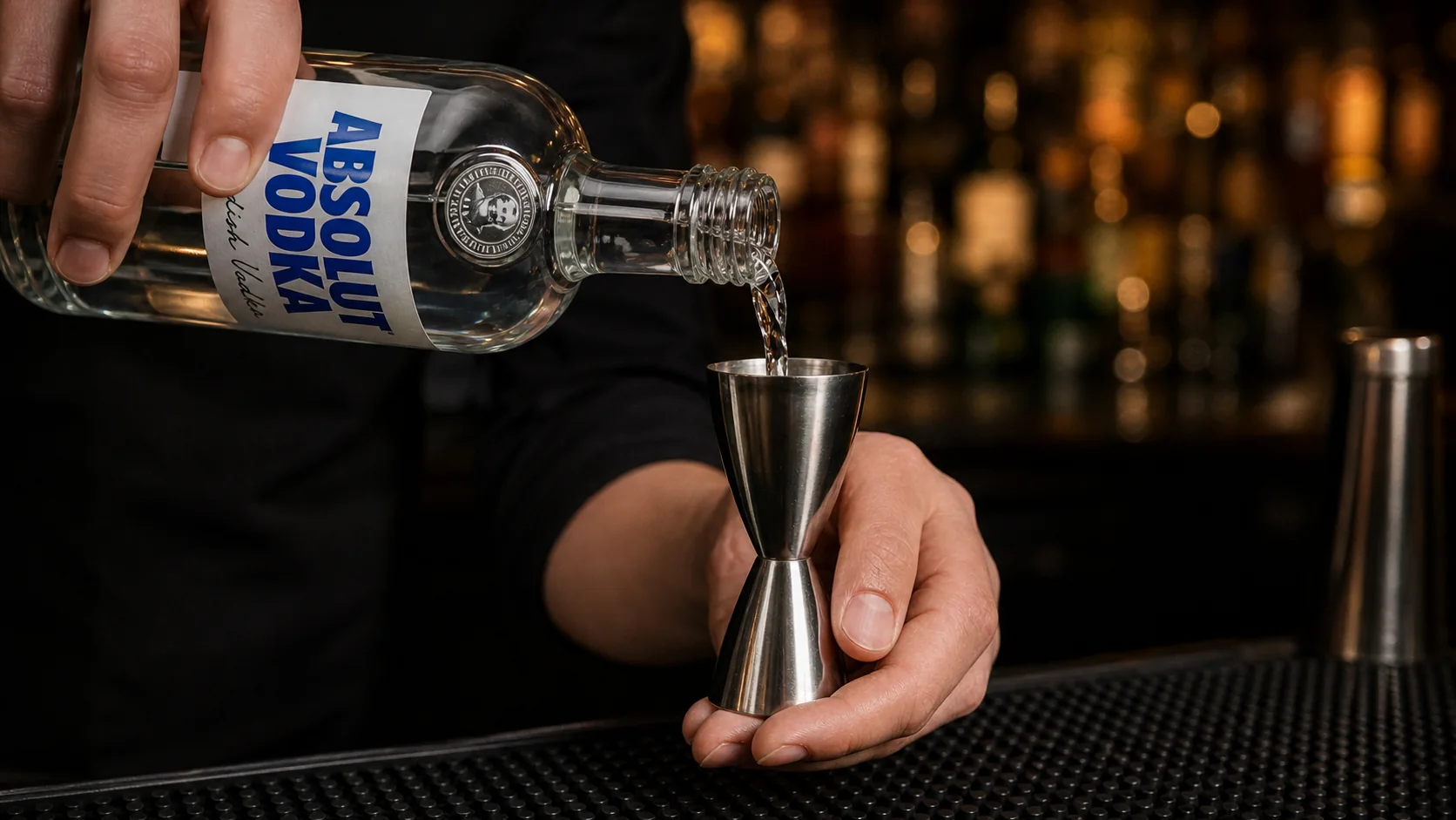 Absolut Vodka wird kontrolliert in einen Metalljigger abgemessen